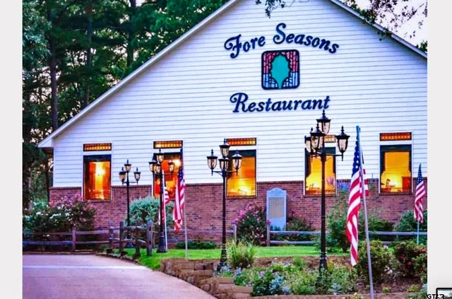 a front view of multi story residential apartment building with yard and entertaining space