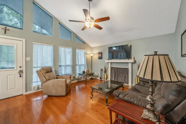 a living room with furniture a flat screen tv and a large window