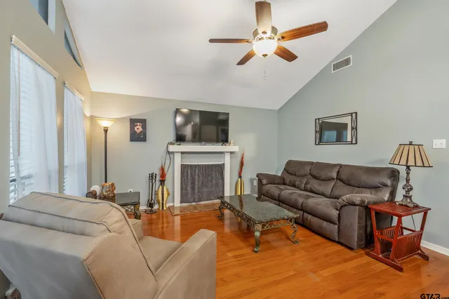 a living room with furniture a fireplace and a flat screen tv