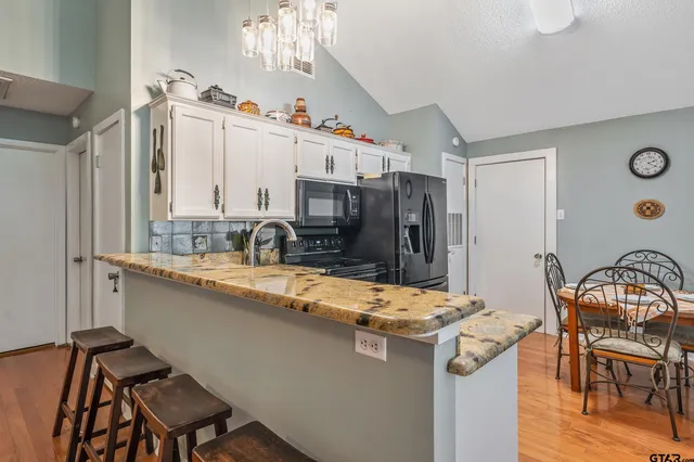 a kitchen with stainless steel appliances granite countertop a sink stove and a refrigerator