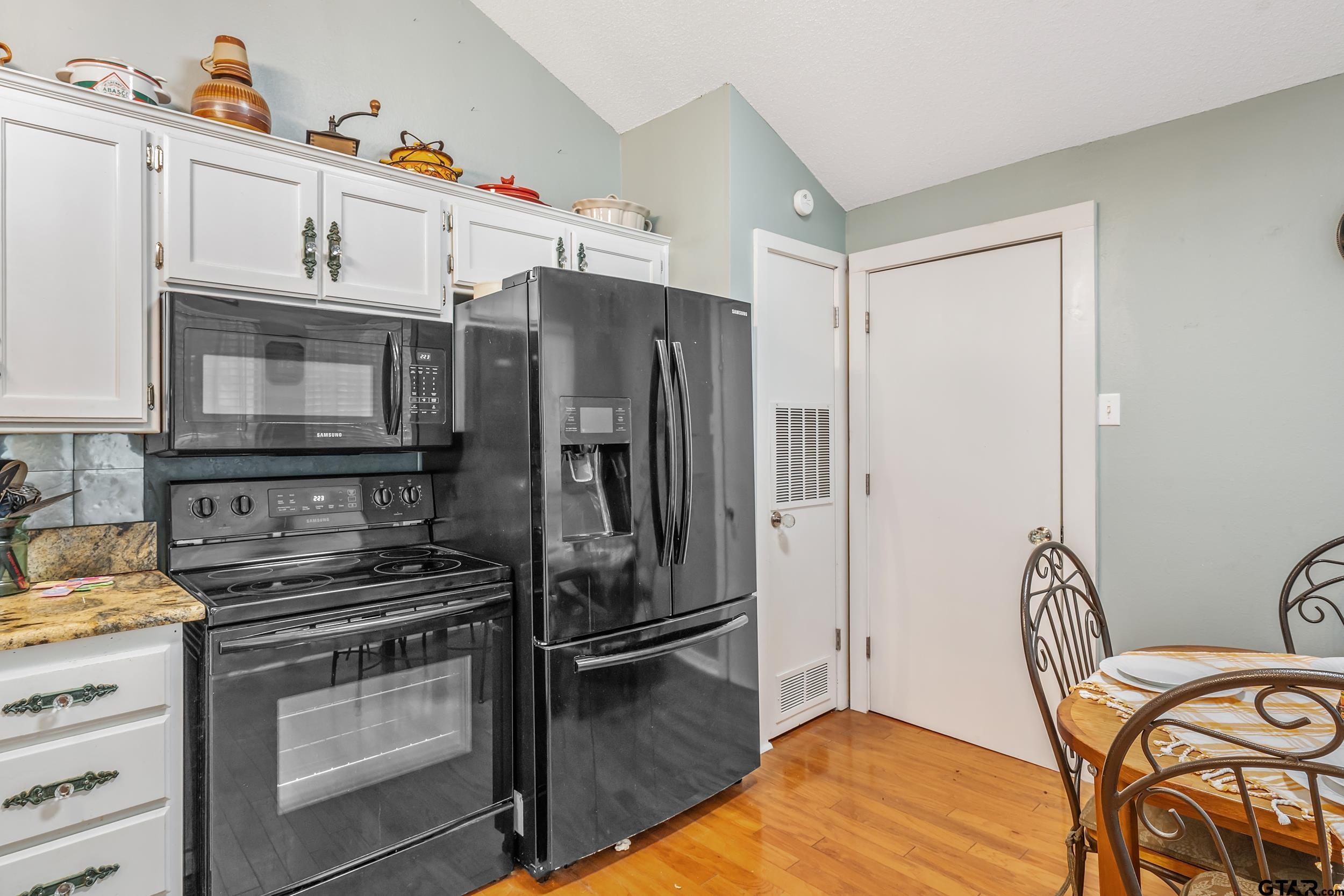 201 Elmwood Lane Holly Lake Ranch, TX 75765 - Photo 8 of 34 a kitchen with stainless steel appliances a refrigerator and a stove top oven