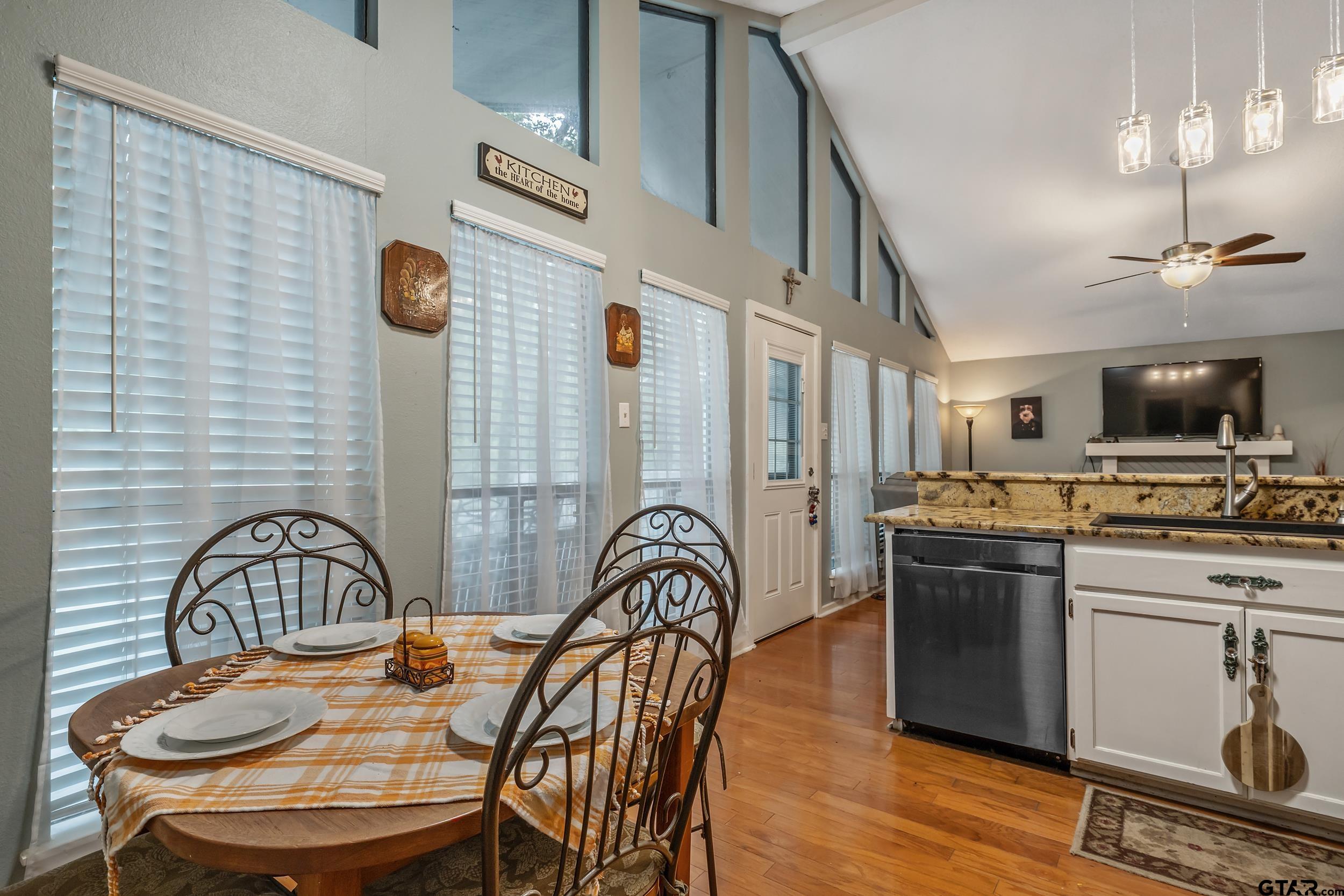 201 Elmwood Lane Holly Lake Ranch, TX 75765 - Photo 10 of 34 a view of a kitchen with a sink a kitchen island a dining table and chairs