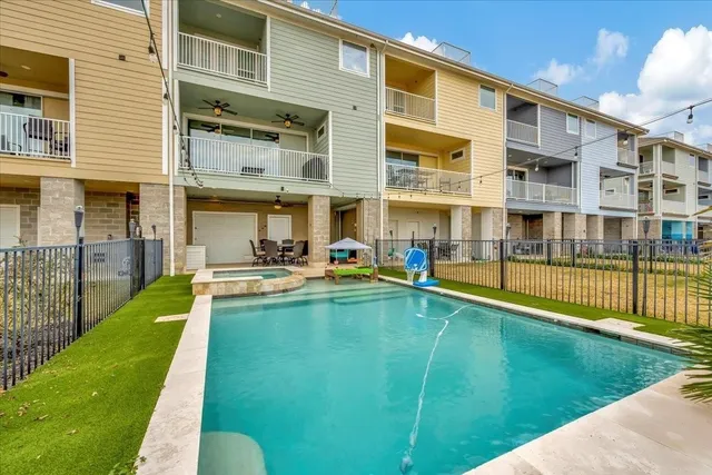 a view of swimming pool with a big yard and large trees