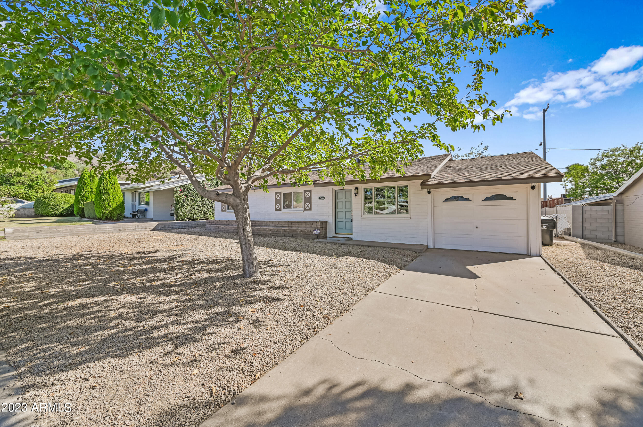 1227 East Las Palmaritas Drive Phoenix, AZ 85020 - Photo 1 of 22 a front view of a house with a yard and garage
