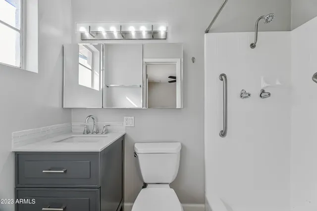 a bathroom with a toilet sink and mirror