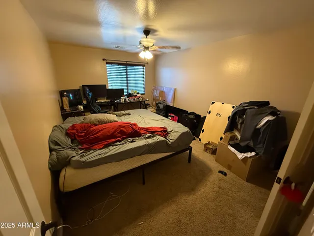 a bed sitting in a bedroom and chair with dishwasher
