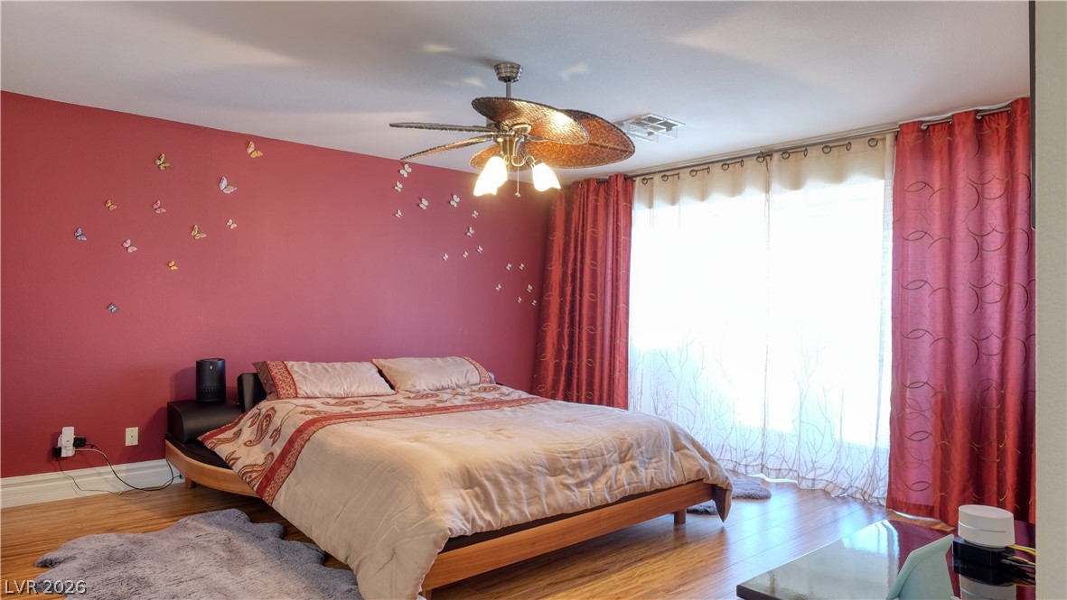 3704 North Campbell Road Las Vegas, NV 89129 - Photo 33 of 46 Hardwood floors and a ceiling fan create comfort in this naturally illuminated sleeping space.