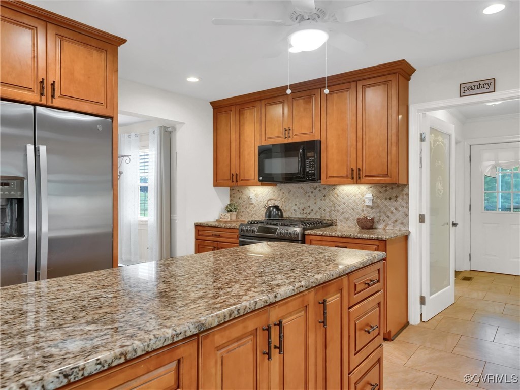 727 Eanes Road Kenbridge, VA 23944 - Photo 15 of 50 a kitchen with stainless steel appliances granite countertop a refrigerator a stove and a sink with wooden floors