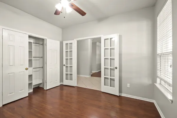 an empty room with wooden floor and windows