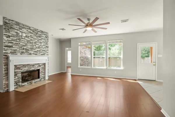 a view of empty room with wooden floor and fireplace