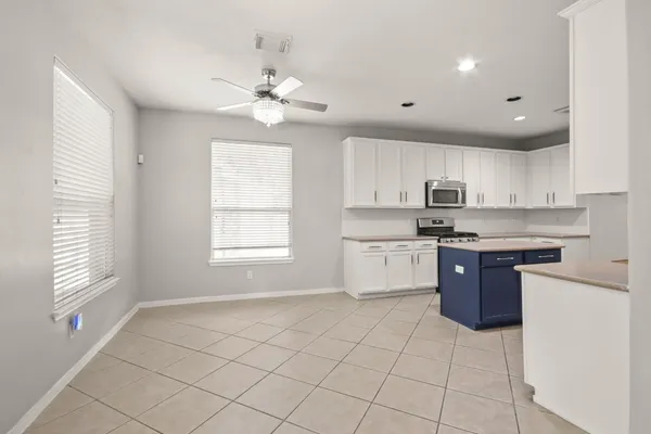 a kitchen with a table chairs microwave and cabinets