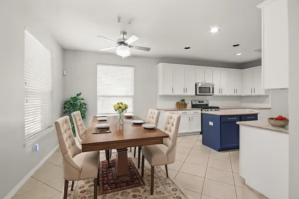 a kitchen with a table chairs microwave and cabinets