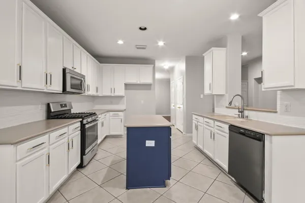 a large kitchen with stainless steel appliances granite countertop a sink and cabinets
