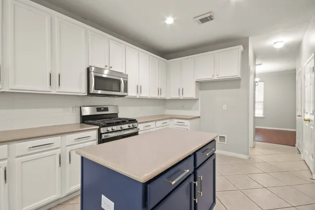 a kitchen with cabinets appliances a sink and a counter top space