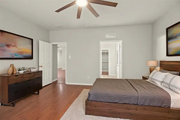 an empty room with wooden floor closet and windows