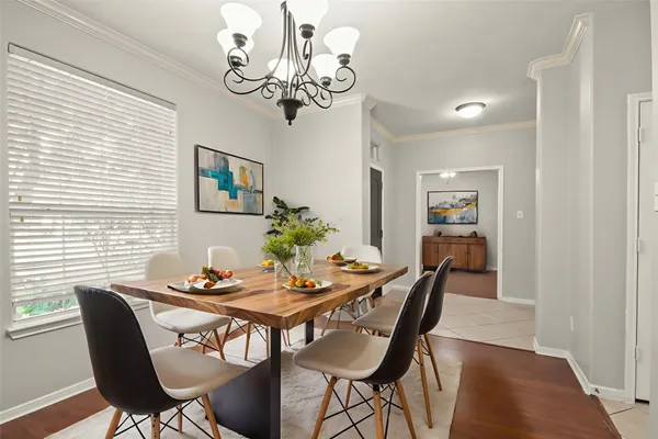 a view of a dining room with furniture a chandelier and wooden floor