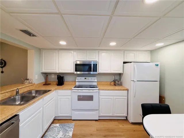 a kitchen that has a microwave a sink and a stove in it