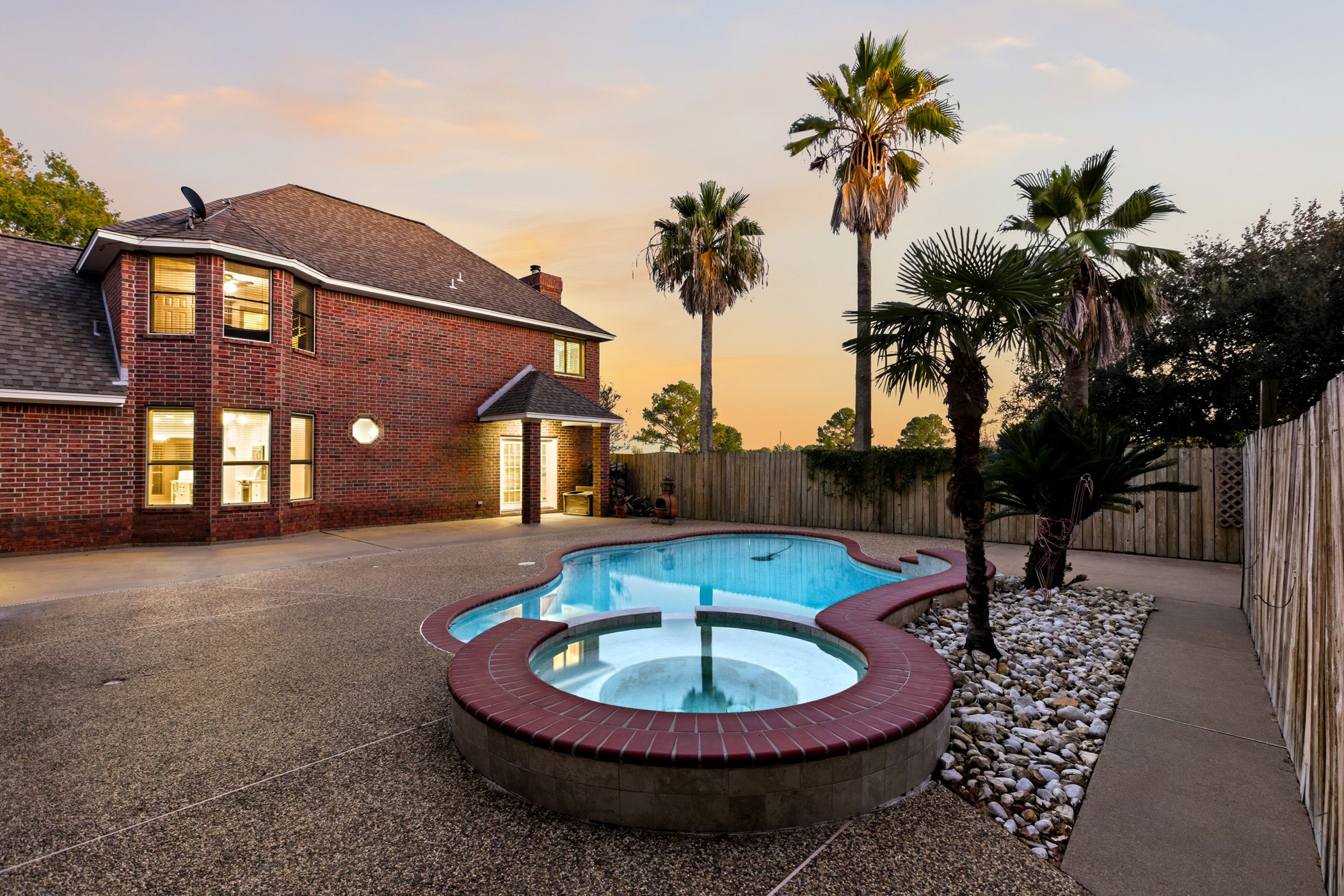 17207 Penick Road Waller, TX 77484 - Photo 3 of 37 The back yard features a large patio for entertaining and al fresco dining. The playful pool and spa is surrounded by a wood privacy fence and mature trees. The area is landscaped with palm trees, live oaks and greenery which creates a private and relaxing outdoor oasis.