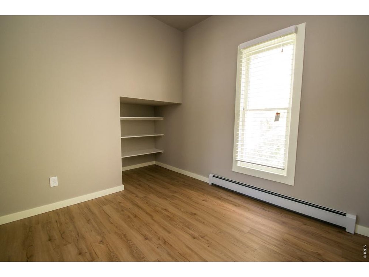 1806 17th Street Boulder, CO 80302 - Photo 16 of 45 a view of an empty room with a window and wooden floor