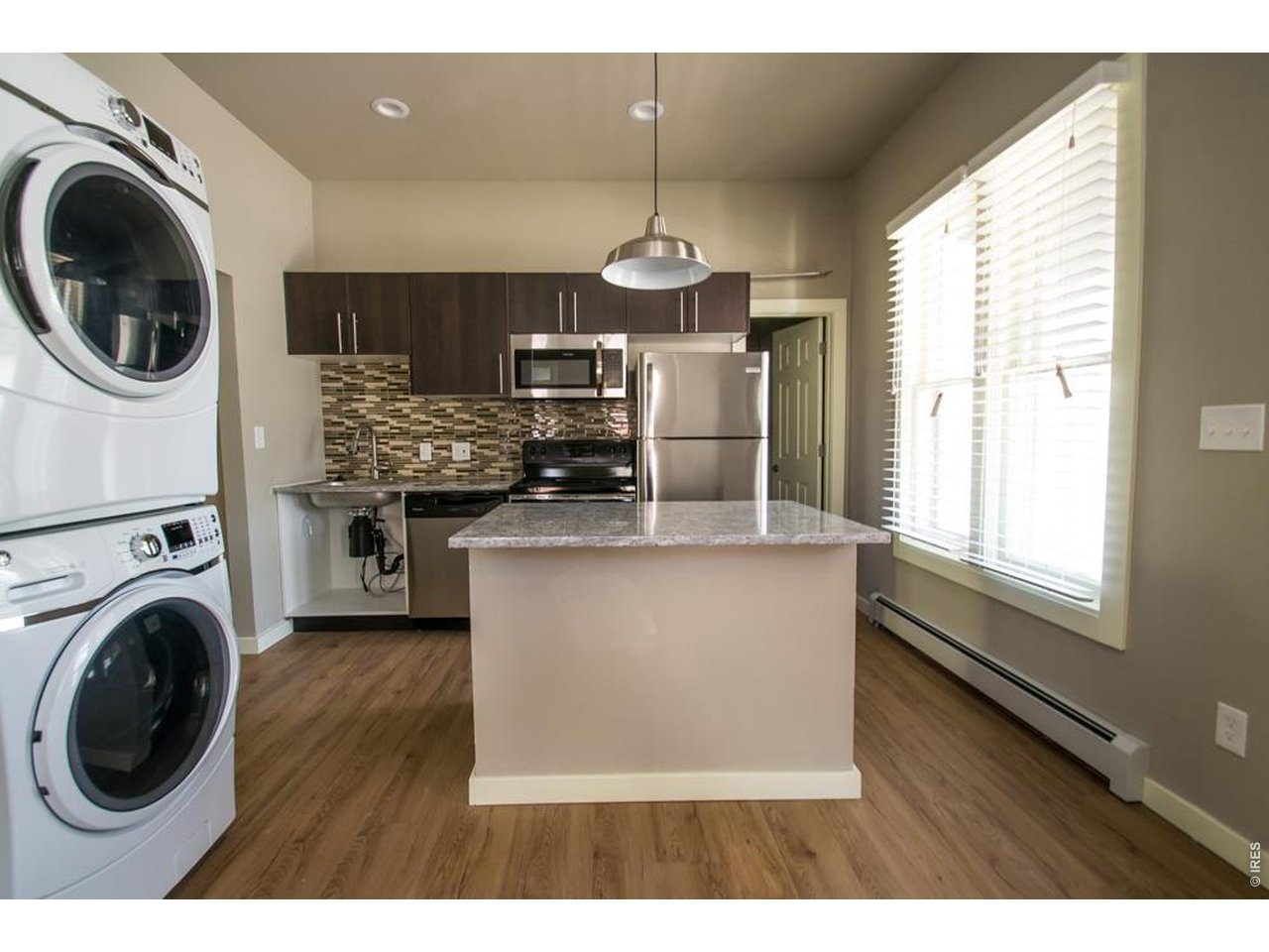 1806 17th Street Boulder, CO 80302 - Photo 8 of 45 a kitchen with kitchen island a stove a sink and wooden floors