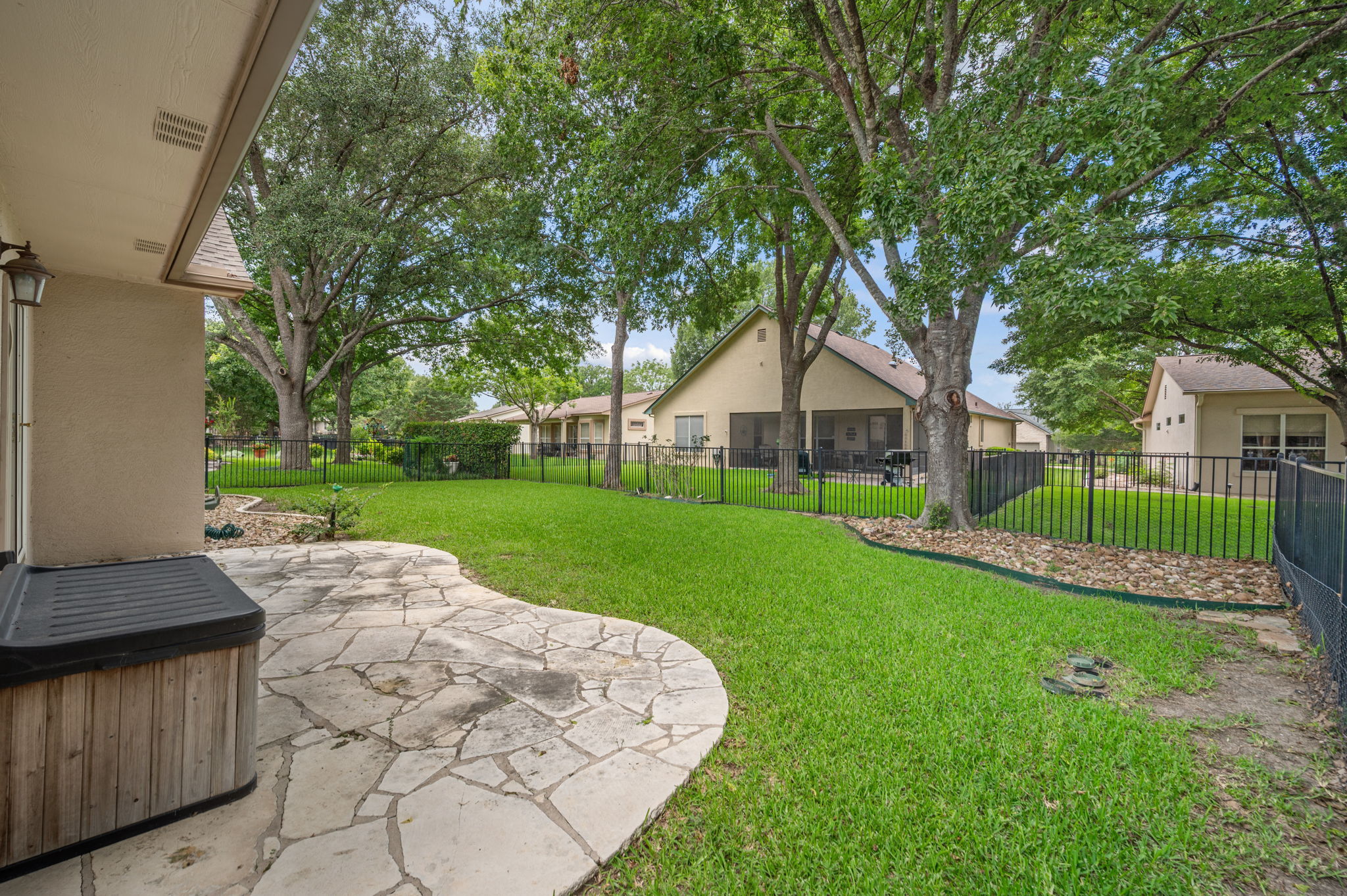 118 Bass Street Georgetown, TX 78633 - Photo 33 of 40 A private yard with mature trees and a stone patio provides a serene outdoor escape.