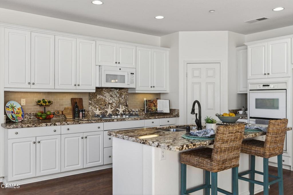 2914 Naples Drive Oxnard, CA 93035 - Photo 3 of 51 a kitchen with kitchen island granite countertop a sink and white cabinets