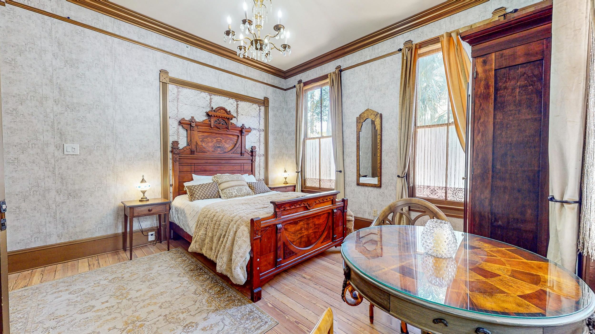 63 Orange Street St. Augustine, FL 32084 - Photo 20 of 74 a spacious bedroom with a bed and a chandelier