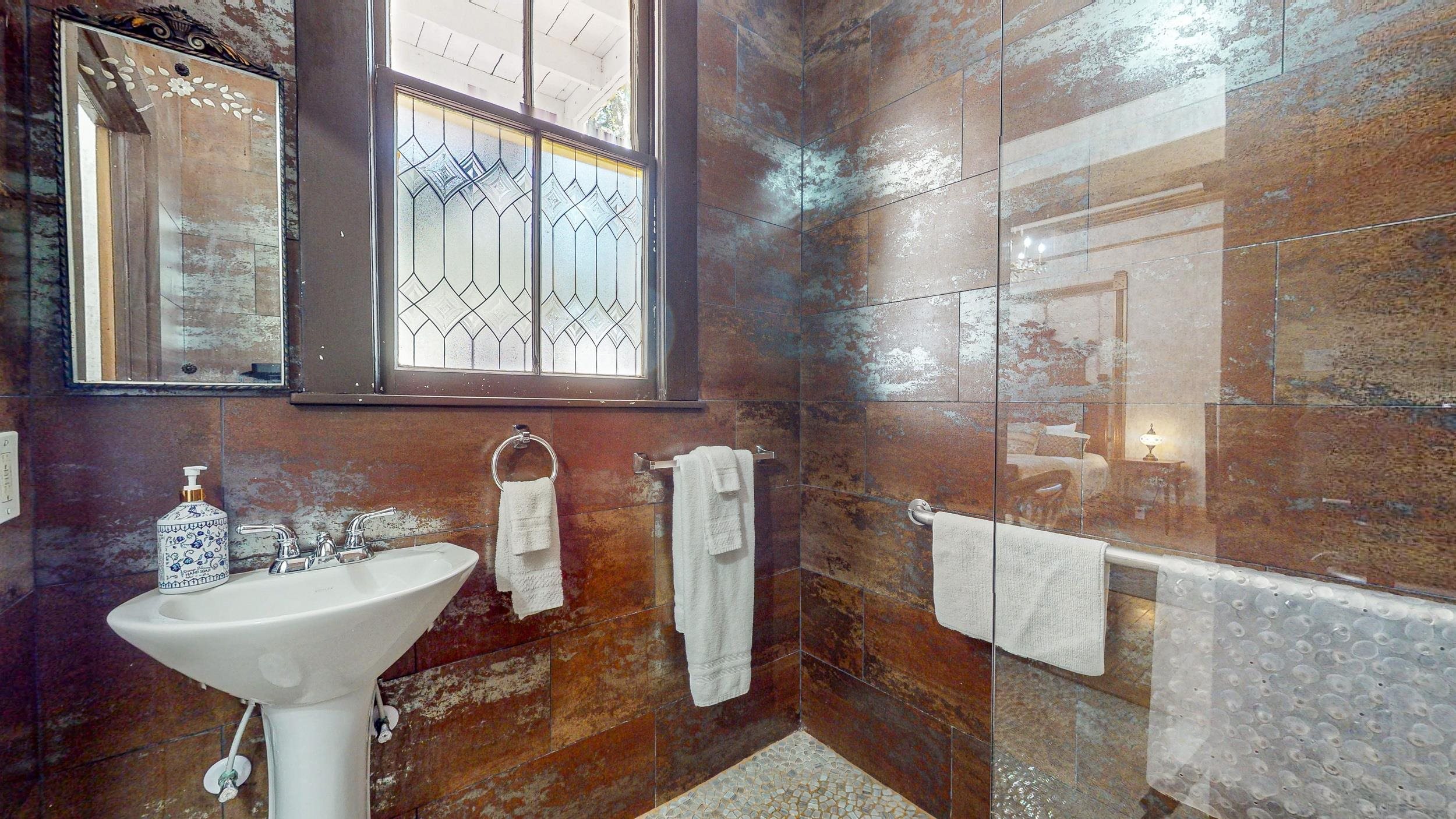 63 Orange Street St. Augustine, FL 32084 - Photo 23 of 74 a bathroom with a sink and mirror with bathtub