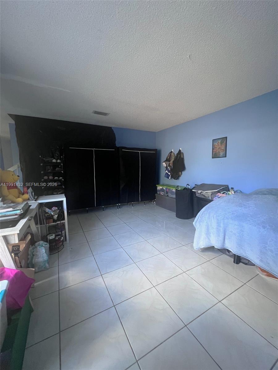 4681 Cherry Road West Palm Beach, FL 33417 - Photo 11 of 33 a bedroom with furniture and a potted plant