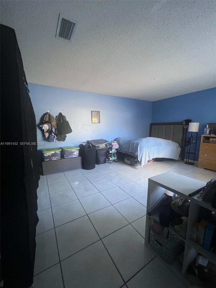 4681 Cherry Road West Palm Beach, FL 33417 - Photo 13 of 33 a bedroom with a bed and a table in it