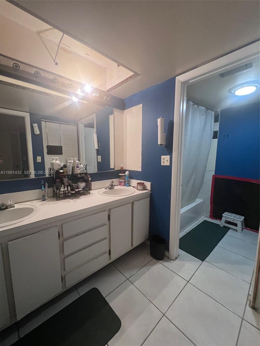 4681 Cherry Road West Palm Beach, FL 33417 - Photo 29 of 33 a bathroom with a sink a mirror and a shower