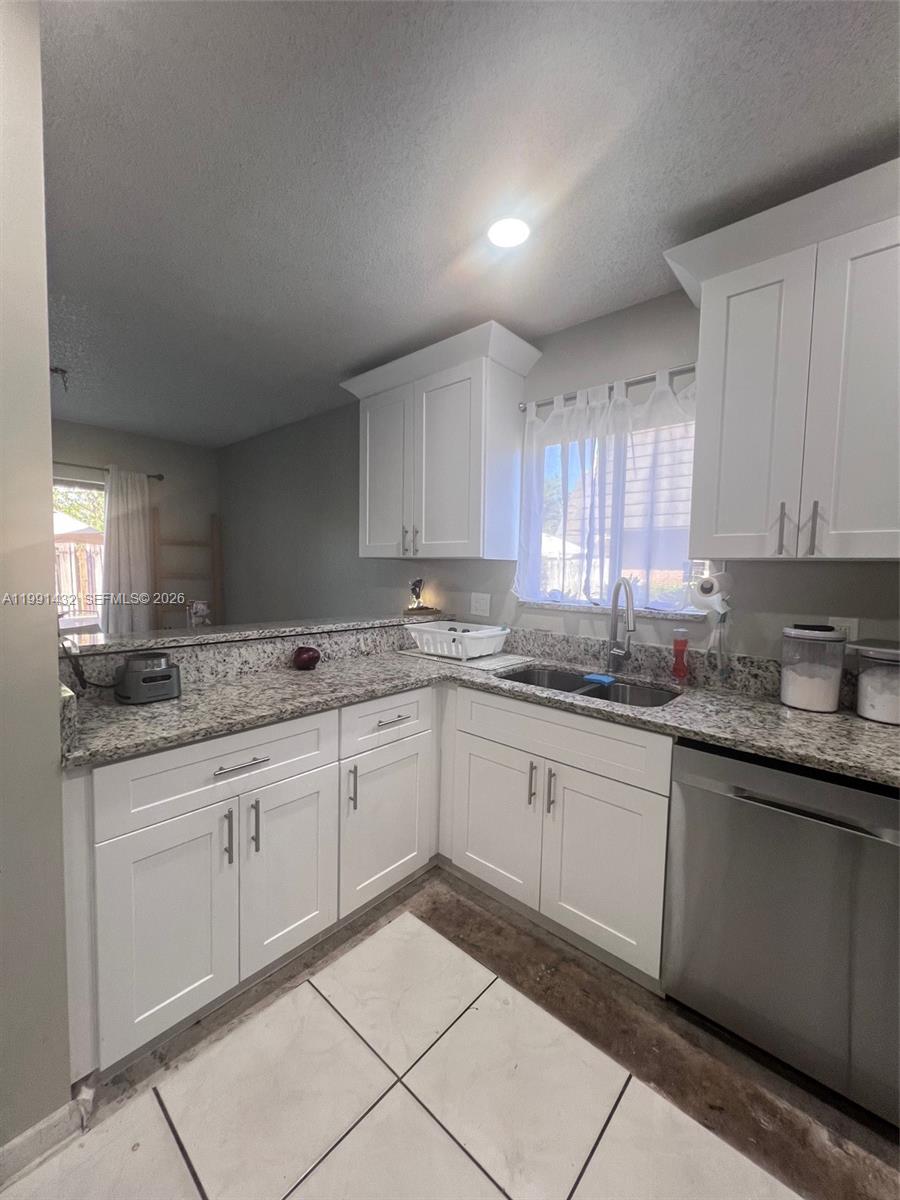 4681 Cherry Road West Palm Beach, FL 33417 - Photo 10 of 33 a kitchen with granite countertop sink and cabinets