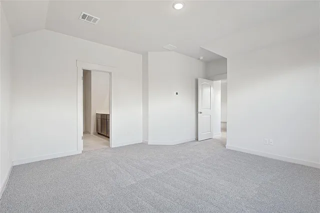 an empty room with wooden floor a ceiling fan and windows