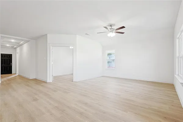 a kitchen with stainless steel appliances granite countertop a stove top oven a sink a refrigerator and white cabinets with wooden floor