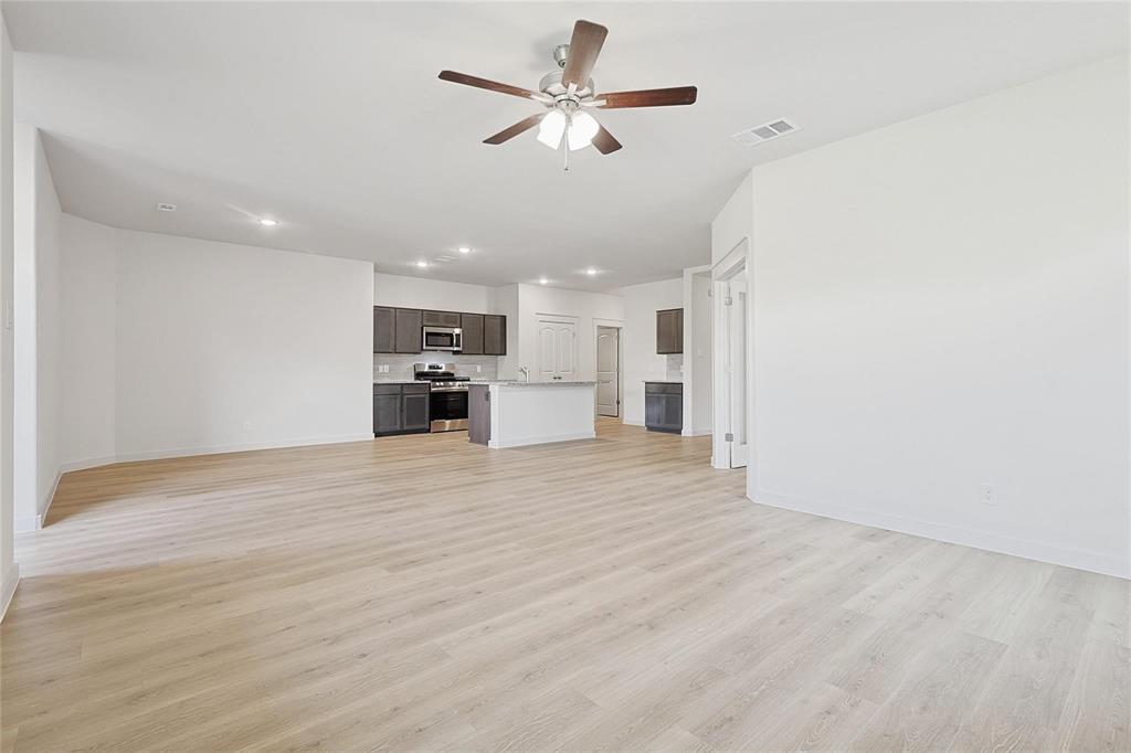 1759 Gleasondale Place Forney, TX 75126 - Photo 8 of 25 a view of a kitchen with a kitchen island wooden floor and a ceiling fan