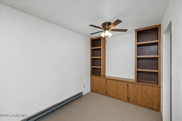 an empty room with a window and a fan