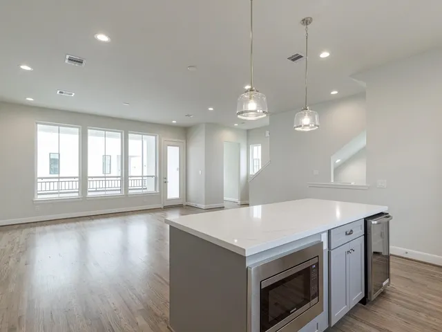 a kitchen that has a sink a stove and wooden floor