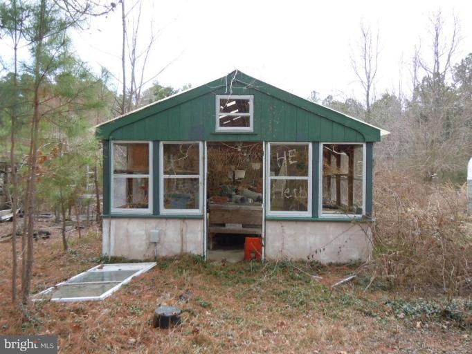 8721 Cummings Road Wittman, MD 21676 - Photo 2 of 4 a front view of a house with a yard and garage