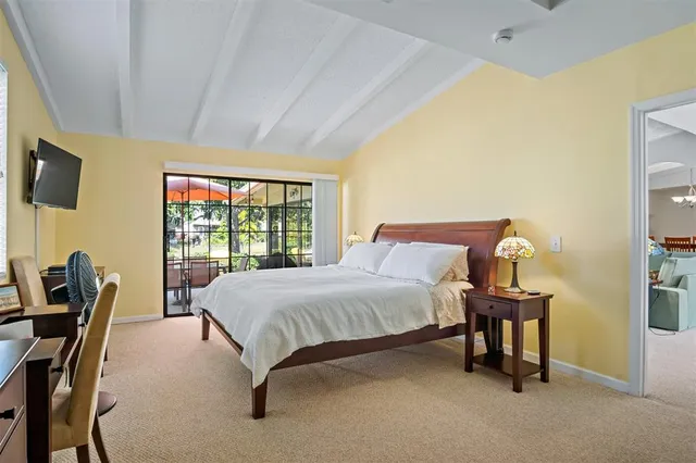 a spacious bedroom with a bed and a tv on table
