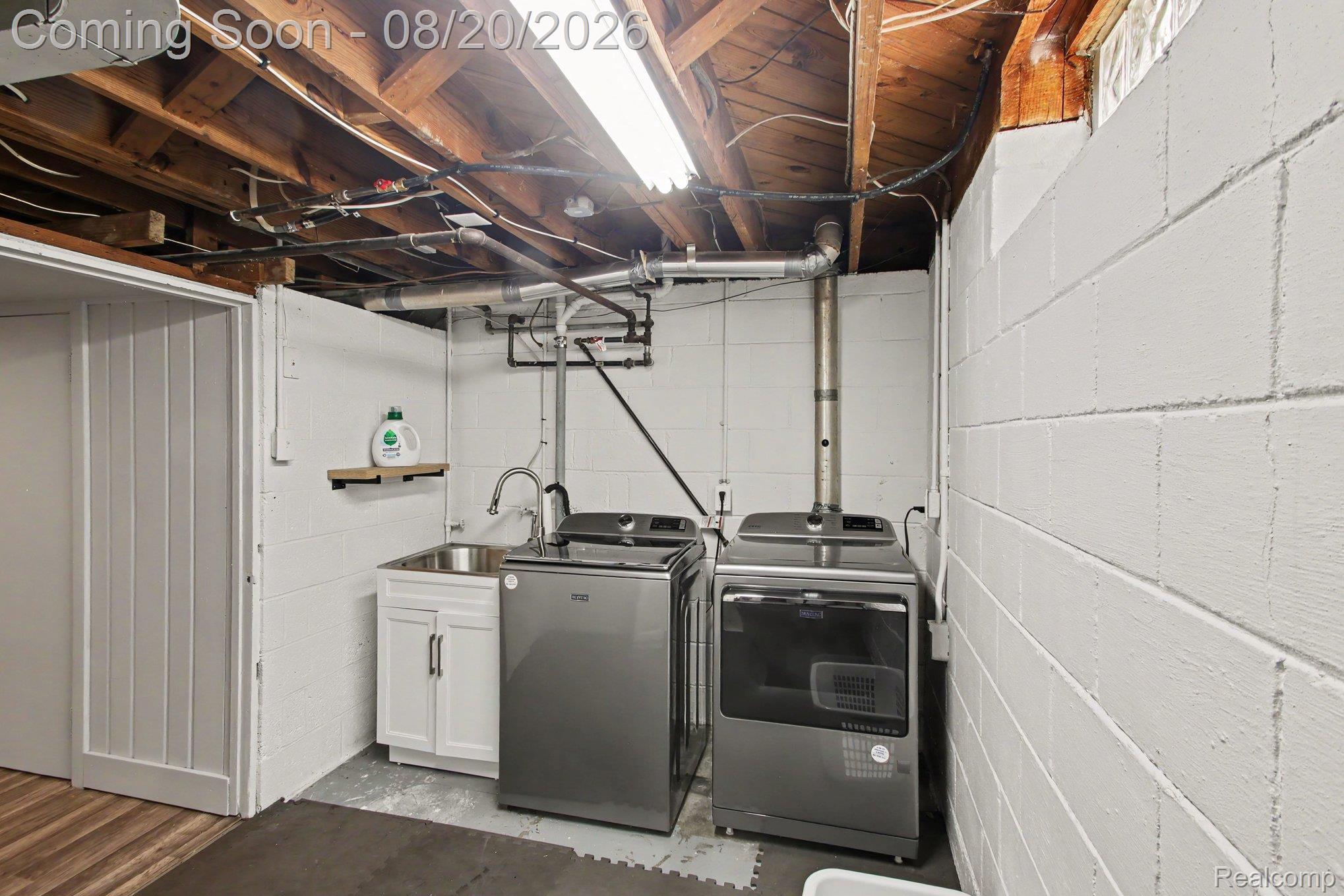 4098 Wakefield Road Berkley, MI 48072 - Photo 38 of 49 Utility area featuring a laundry sink with a single-handle faucet, white cabinetry, and exposed ceiling joists