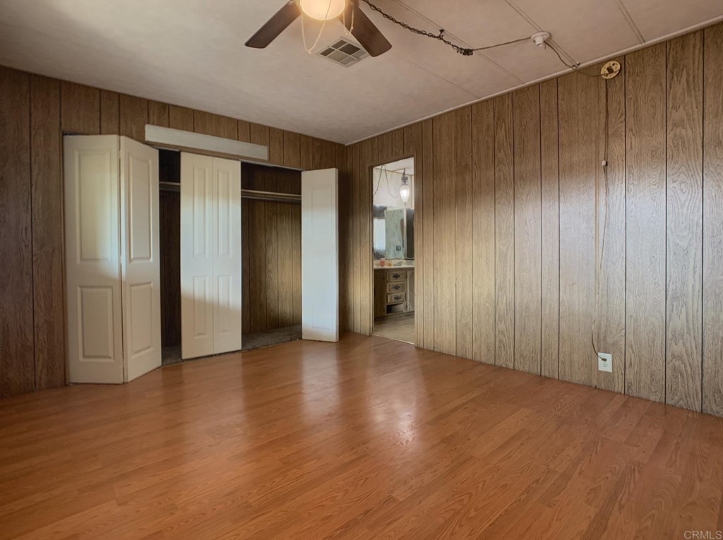 400 Greenfield Drive, Unit 150 El Cajon, CA 92021 - Photo 19 of 21 an empty room with wooden floor ceiling fan and windows