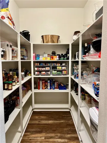 a dining room with wooden floor a chandelier a wooden table and chairs