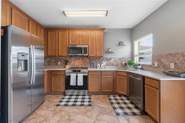 a kitchen with stainless steel appliances granite countertop a refrigerator sink and microwave