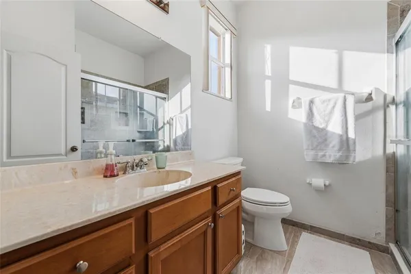 a bathroom with a granite countertop sink a toilet and a mirror