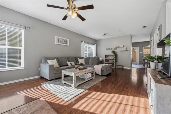 a living room with furniture and a wooden floor