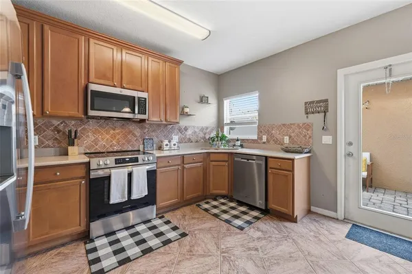 a kitchen with stainless steel appliances granite countertop a stove a sink and a microwave