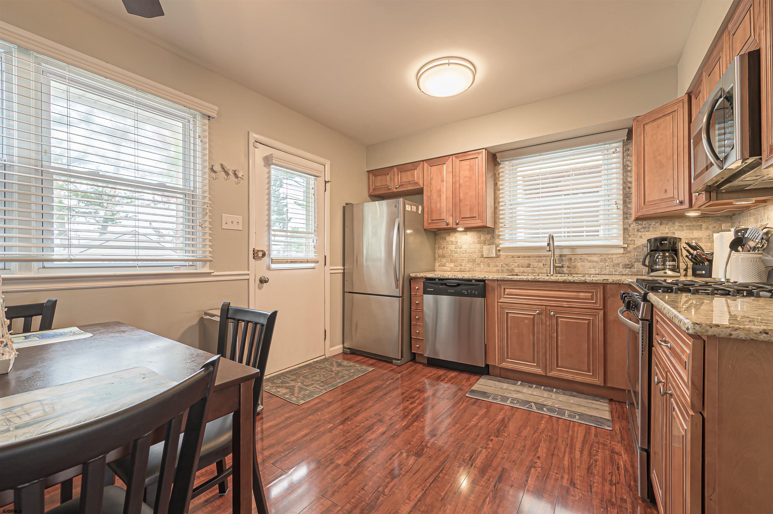 138 44th Street South, Unit D Brigantine, NJ 08203 - Photo 8 of 25 a kitchen with a table chairs a sink dishwasher window and cabinets
