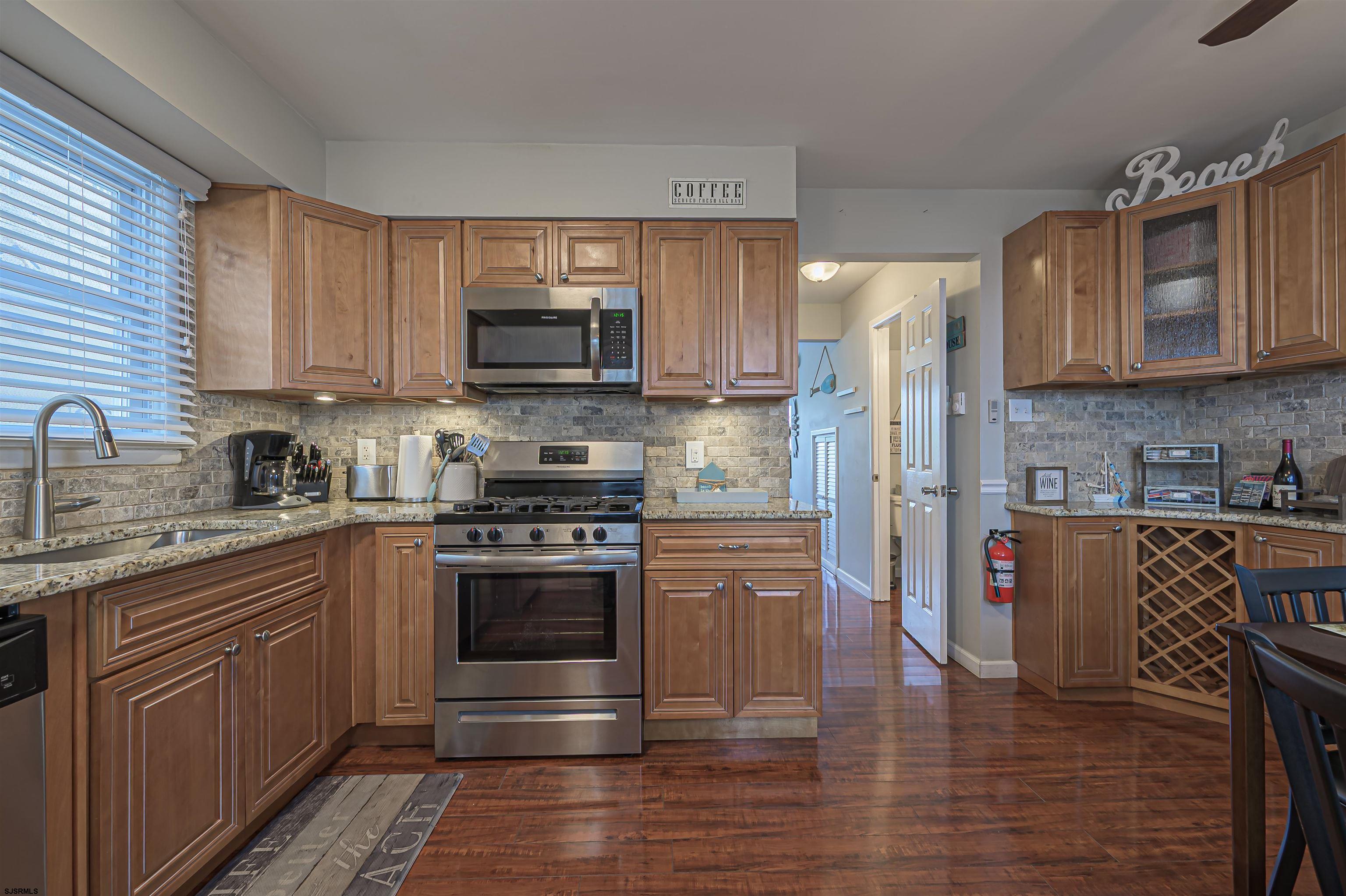 138 44th Street South, Unit D Brigantine, NJ 08203 - Photo 10 of 25 a kitchen with stainless steel appliances granite countertop a stove top oven a sink dishwasher a refrigerator and a microwave