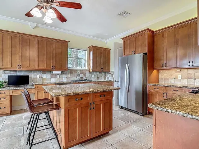 a kitchen with stainless steel appliances granite countertop a refrigerator and a stove top oven