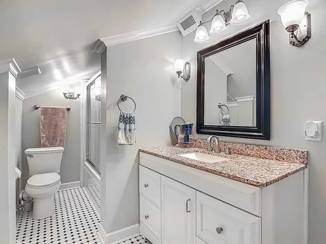 a bathroom with a granite countertop sink a toilet and a mirror